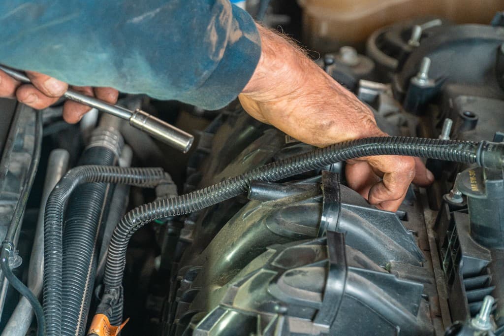 Mechanic working on a car engine at Auto Experience